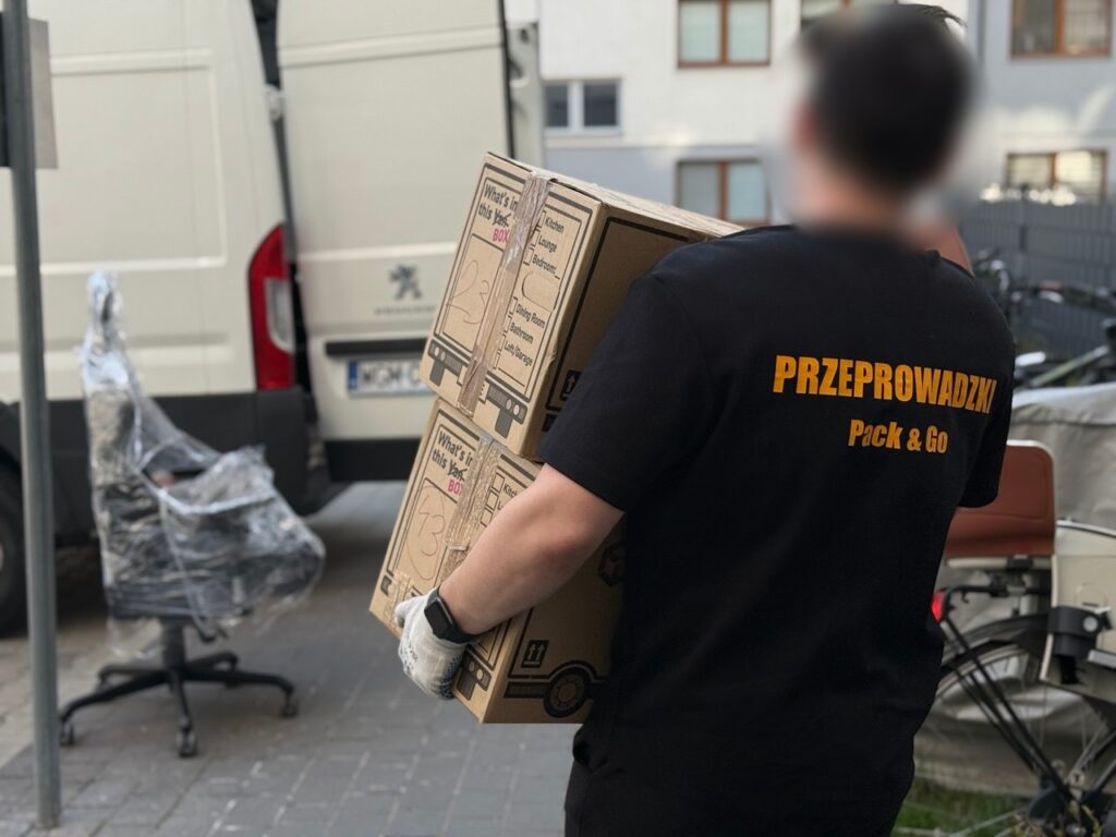 Pracownik Go Przeprowadzki wnosi zabezpieczony mebel z busa podczas przeprowadzki w Warszawie