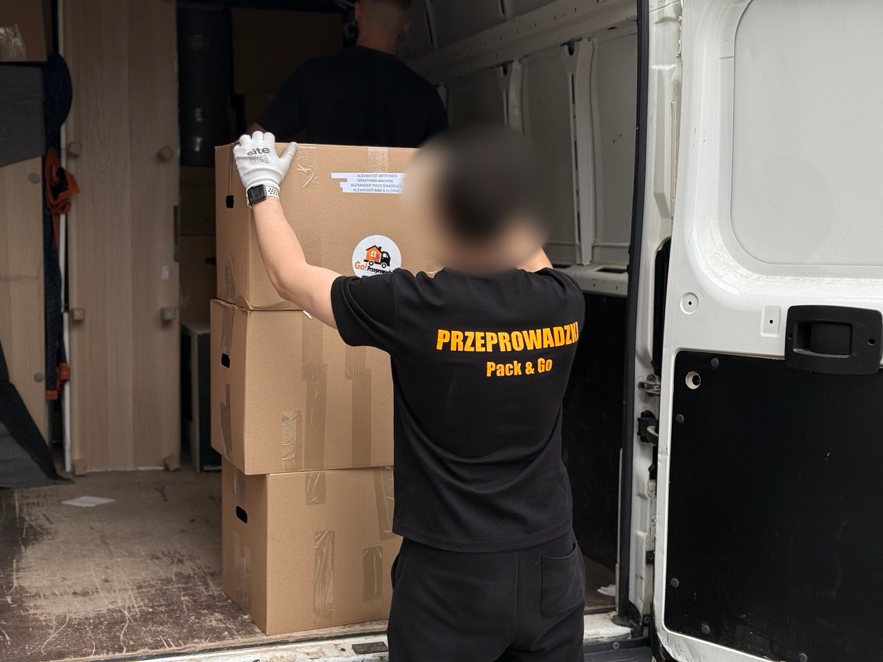 Pracownik Go Przeprowadzki ładuje kartony do busa podczas przeprowadzki w Warszawie